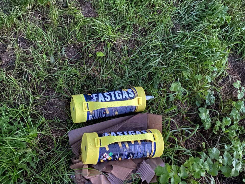 Lachgas containers in het gras